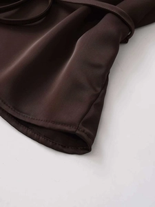 Detailed view of the dark brown V-neck shirt hem showing clean stitching and smooth fabric