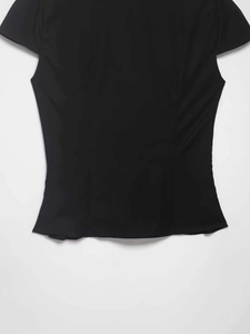 Detail view of the slimming waistline and flutter sleeves of this black short sleeve shirt