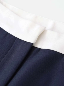 Detailed close-up of navy blue and white contrast stitching on the straight trousers