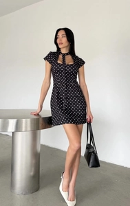 Détail de la robe courte vintage à pois avec encolure découpée et lien à la taille