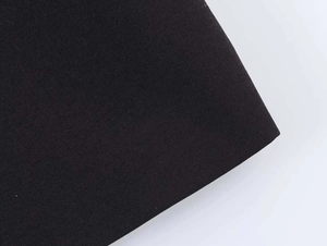Close-up detail of premium black woven fabric showing dense texture and smooth finish