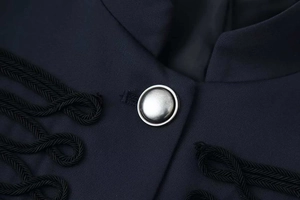 Detailed close-up of a silver metal button with military-style braided rope on black fabric