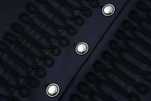 Close-up of military-style braided frogging and silver metallic buttons on a black jacket