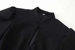 Detail of mandarin collar and teardrop cutout on this black puff sleeve blazer top