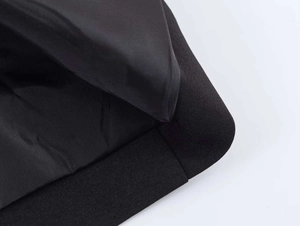 Detailed macro view of black synthetic fabric texture with smooth inner lining and stitching