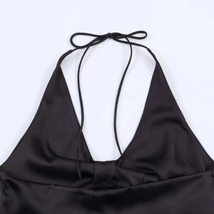 Detail of the plunging V-neckline and halter neck ties on a black satin finish top