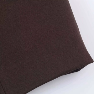 Dettaglio ravvicinato del tessuto twill marrone scuro che mostra la trama fine del materiale