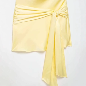 Elegant pale yellow satin mini dress with waist knot detail and hanging ribbon sash