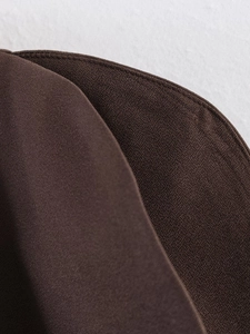 Detailed macro view of high-quality dark brown fabric texture and precise stitching detail