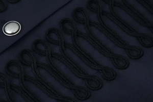 Macro shot of navy blue fabric with black braided nautical trim and silver metal button
