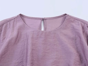 Detail der lavendelfarbenen Bluse mit Rundhalsausschnitt und Tropfenverschluss hinten