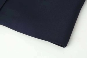Close-up of navy blue premium blazer fabric texture with clean stitched edges