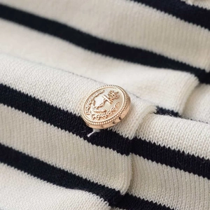 Classic striped knit sweater with ornate gold anchor crown buttons in a close-up view