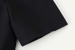 Detail of the high-quality black fabric texture and clean stitching on the sleeve edge