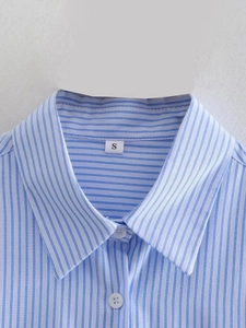 Detail shot of blue and white striped shirt collar with size S label and buttons