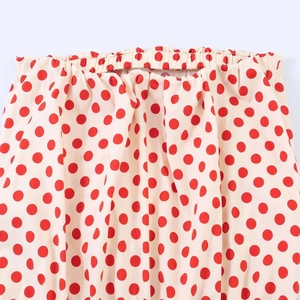 Detail of elastic waist on beige polka dot top featuring gathered fabric and premium stitching