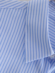 Detail of blue and white striped shirt collar showing fabric texture and neat stitching