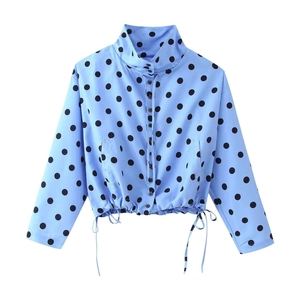 Detailed view of polka dot shirt featuring a stand collar and drawstring hem