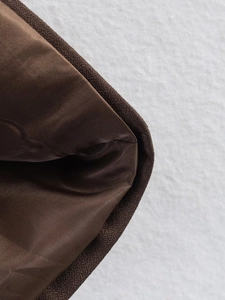 Macro shot of dark brown twill fabric lining with detailed stitching on interior edge