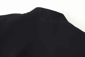 Close-up of the standing collar and button detail on this slim black short sleeve blazer