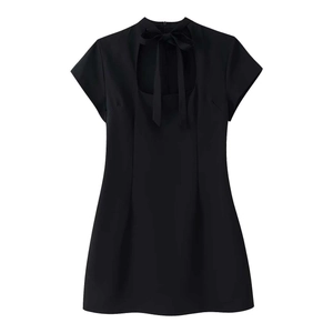 Détail de robe noire vintage à pois avec découpe au dos et nœud papillon élégant