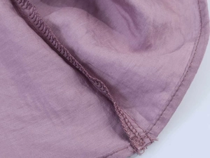 Detailansicht aus lila Leinenstoff mit professionellen Nähten und Kantenverarbeitung