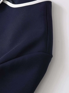 Detail of navy woven fabric with white contrast piping and high-quality stitching