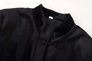 Dettaglio del colletto alla coreana e bottone a nodo su giacca di velluto nero