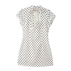 Détail du dos d'une robe à pois avec découpe goutte d'eau et nœud élégant au col