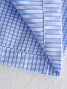 Close-up of fine blue and white striped fabric with neat rolled hem and flat stitching