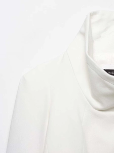 Detail of white structured blazer collar and shoulder with textured woven fabric