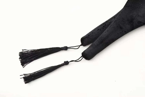 Dettaglio delle nappe in velluto nero di un blazer con trama fine in filo di seta