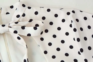 Détail de la robe vintage à pois avec col à nœud papillon et fermeture éclair invisible