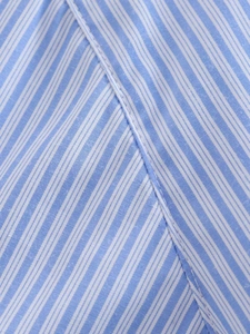 Detailed macro view of blue and white striped fabric with neat stitching and fine texture