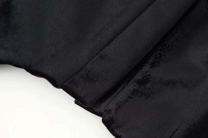 Vista dettagliata della trama in velluto nero di alta qualità su un blazer con collo alto