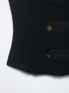 Detail of vintage military style braiding and bronze buttons on black waist waistcoat