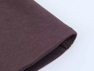 Détail du tissu en maille violet foncé avec doublure polaire et finitions côtelées