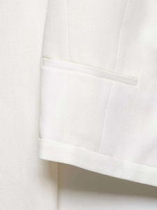 Detailed macro view of white blazer featuring welt pocket and twill fabric texture