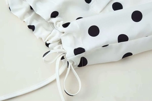 Detail of white polka dot jacket fabric with adjustable drawstring and fine stitching