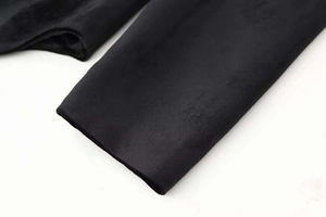Dettaglio della manica del blazer in velluto nero con texture liscia e bordi puliti