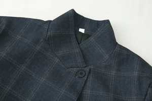 Detail of classic navy plaid blazer showing lapel structure and single black button
