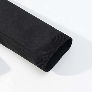 Close-up of ribbed cuffs and twill texture on a black stand collar short jacket