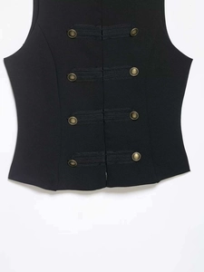 Detailed close-up of decorative bronze buttons and woven frog closures on a black vest