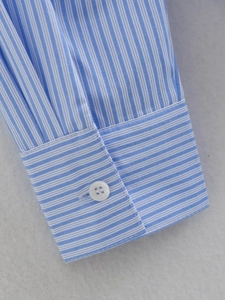 Detailed close-up of blue and white striped shirt cuff with a single white button