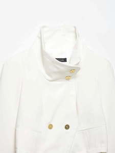 Detail of white stand collar blazer showing textured gold buttons and woven fabric quality