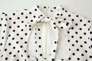Détail d'une robe vintage à pois avec encolure à nœud et découpe en forme de gouttelette