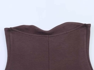 Gros plan du décolleté d'un débardeur en maille marron foncé avec couture verticale soignée