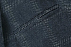 Detail shot of the glen check pattern and pocket stitching on a navy wool blend blazer