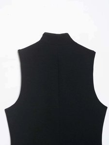 Detail view of the black standing collar vest with textured crepe fabric and clean seams