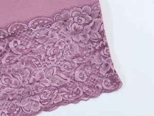 Detailed macro view of elegant purple lace patchwork and rose embroidery on the dress hem